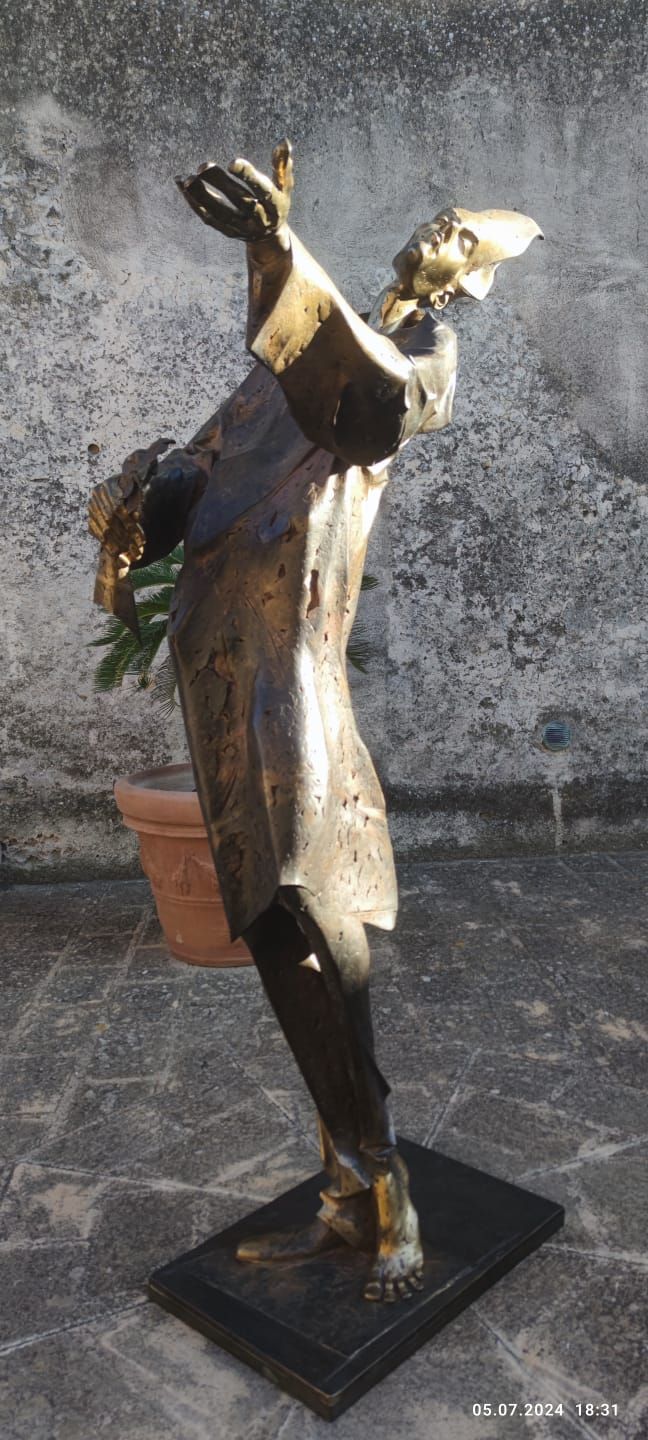 Monumentale Bronzeskulptur einer langgestreckten, aufgerichteten Figur mit erhobenem Arm und geöffnetem Gestus auf schwarzem Sockel. Die Oberfläche aus CuSi3 Siliziumbronze wirkt lebendig und betont Bewegung, Würde und spirituelle Präsenz.